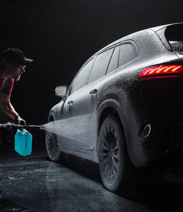 Professional Car Wash Specialist Spraying Smart Foam to Prepare a Modern Black Electric SUV with Contemporary Design for Sale at a Dealership Car Center. Commercial Studio Footage for Advertising